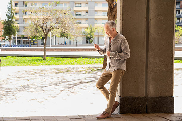 istock Pensioner with phone in modern city 2245991934