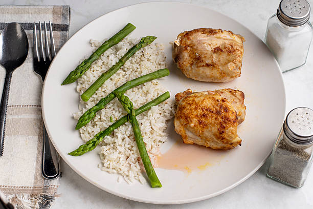 istock chicken thighs  with rice and asparagus 2245992024