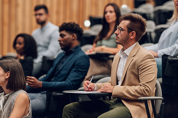 istock People listening and taking notes during a conference seminar 2245992209