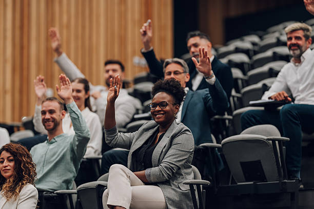 istock Diverse audience raising hands during business conference 2245993151