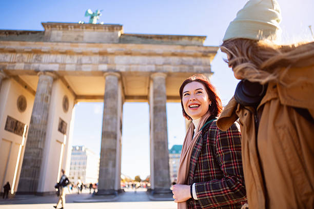 istock Young tourists talking and smiling while passing the Brandenburg Gate in Berlin 2245993562