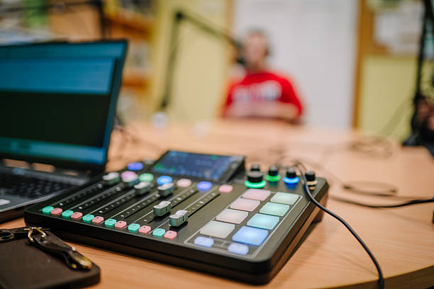 istock Professional audio mixing console with colorful buttons and sliders is positioned on a wooden table in a modern recording studio, capturing the essence of sound production 2245994521