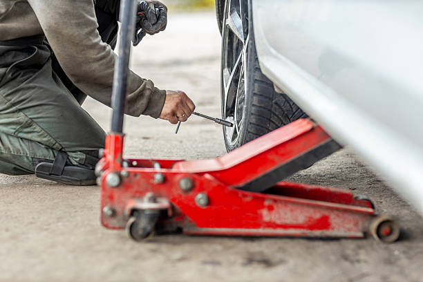 istock Mechanic changing car wheel lifted with hydraulic jack 2245995428