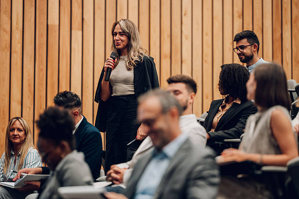 istock Woman speaking into microphone during corporate conference 2245997141