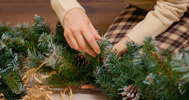 istock Hands skillfully arrange a beautiful decorative fir branch adorned with pinecones 2245997306