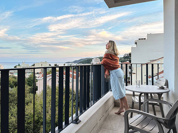 istock A woman standing on the balcony at summer sunset 2245997358