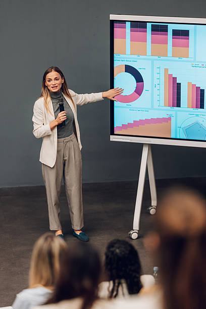 istock Businesswoman giving professional presentation with data charts to audience 2245997614
