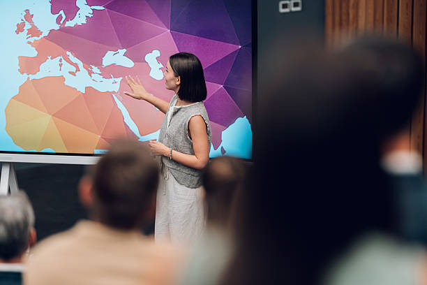 istock Woman speaker presenting world map to audience 2245998186