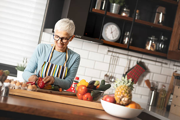 istock happy senior woman chopping vegetables at her kitchen 2245998631