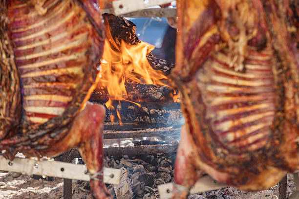 carcass of a pig roasted on a spit over a fire