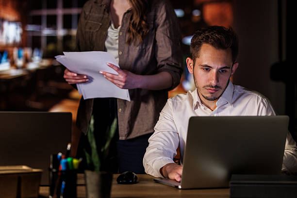istock Manager instructing tasks to a colleague when staying late to finish a project 2246000014