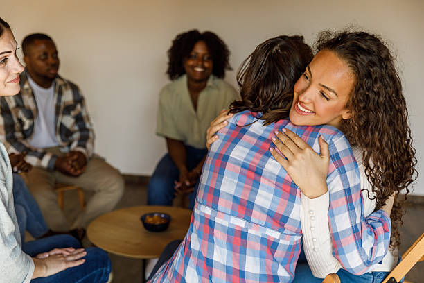 istock Two young women hugging during a successful group therapy session 2246001885