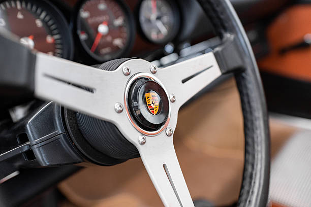 Vilnius, Lithuania - April 11, 2023: 1969 Porsche 911T, surrounded by other vintage cars in a private collection. Car after full restoration, painted in elegant grey colour. Interior shot with Nardi steering wheel and view to instrument cluster.