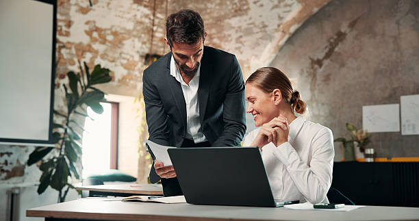 istock Collaboration, documents and laptop with business people in office together for feedback or review. Computer, conversation and paperwork with employee team at desk in workplace for agenda or schedule 2246004512