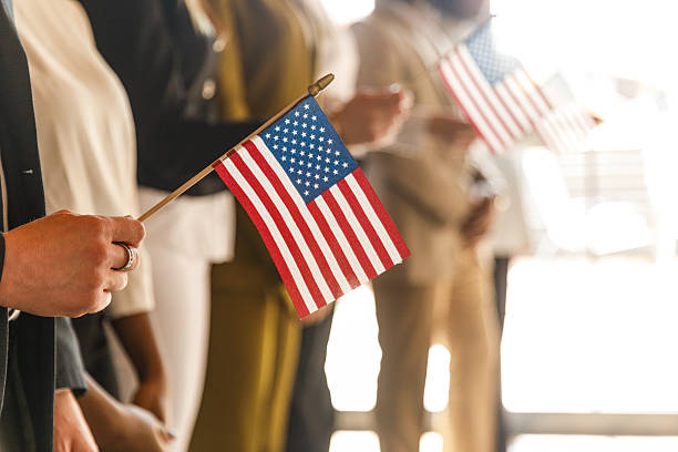 istock Group of people standing in line, holding American flags 2246005472