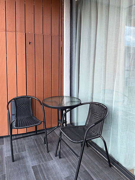 istock Small Outdoor Balcony with Glass Table and Woven Chairs 2246005556