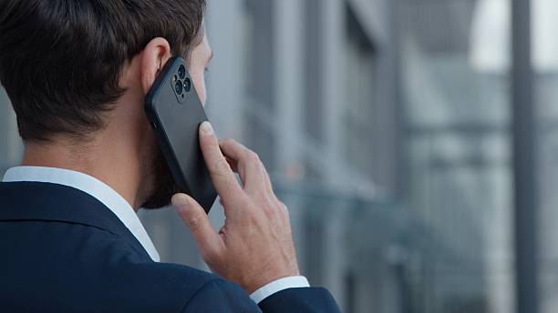 istock Back view unrecognizable Caucasian businessman talking phone business call man speaking discussion mobile male calling in city unknown professional talk near office building corporate negotiating 2246006627