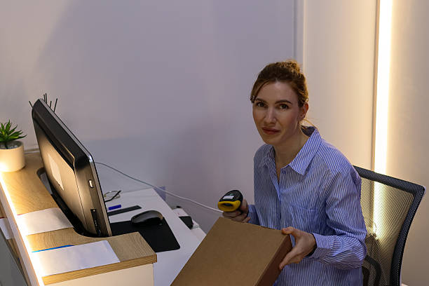 istock Employee holding box and scanner looking ahead 2246006733