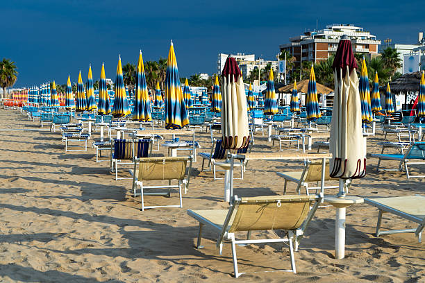 istock Sun loungers on sandy beach with Umbrellas. Empty seaside resort. Italy. 2246009856