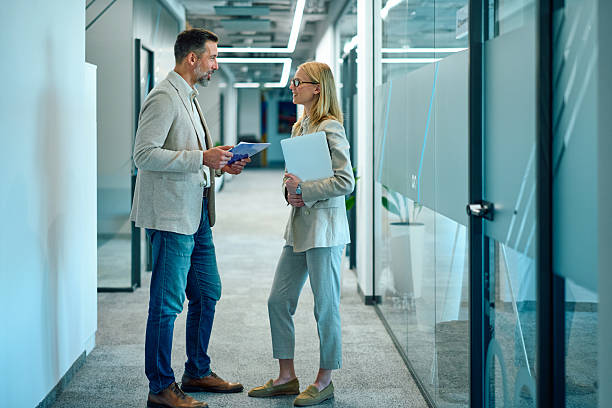 istock Business colleagues discussing project in office corridor 2246010510