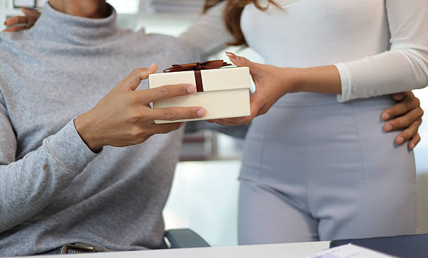 istock Happy couple exchanging a surprise gift box 2246010764