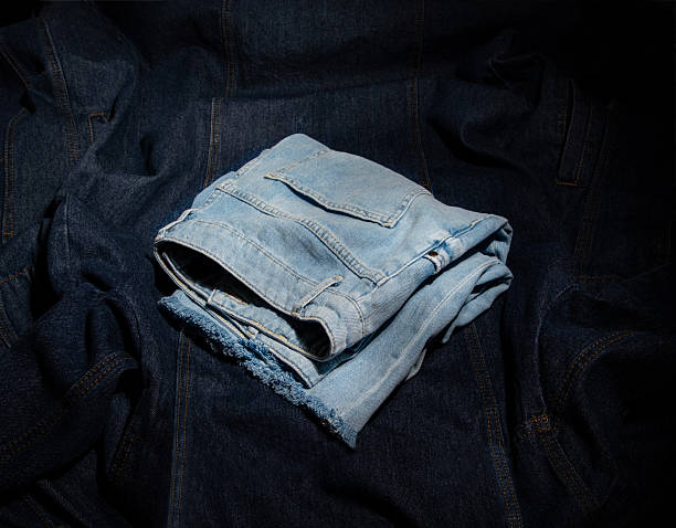 istock Light blue denim shorts lie on blue denim fabric. 2246010967