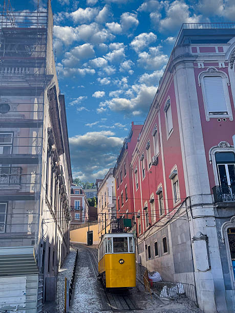 A classic yellow tram climbs a steep cobblestone street