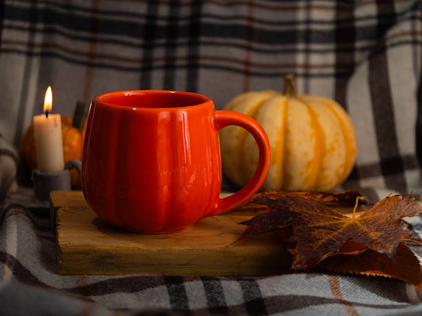 istock Orange Pumpkin mug of tea on warm candlelight background 2246015603