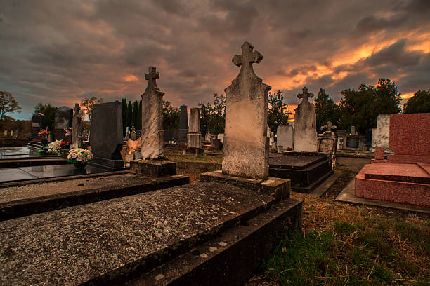 Silhouette of graveyard, the image shows many tombstone,  with dramatic cloudy sky, the image in dark tone.