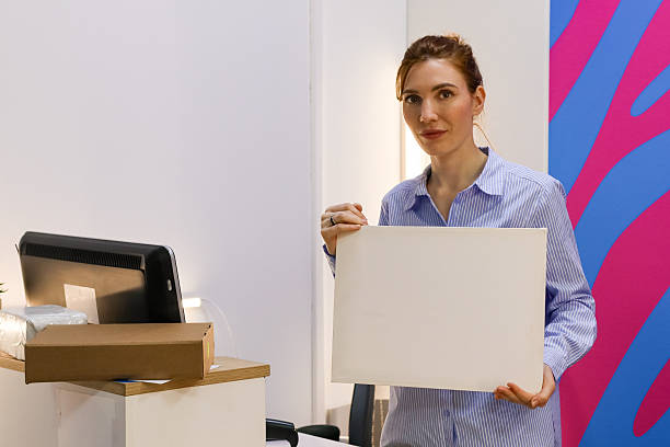 istock Woman presenting white sheet and holding scanner at workstation 2246017433