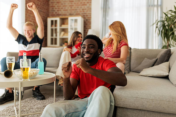 istock Friends Celebrating Victory While Watching Sports Match at Home 2246020562