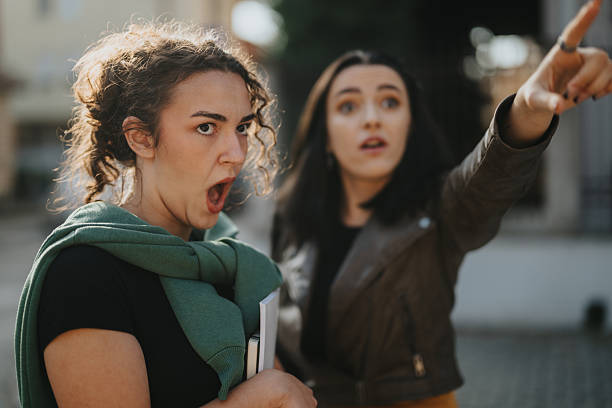 istock Two women reacting dramatically outdoors, one shouting and the other pointing toward something in the distance 2246021070