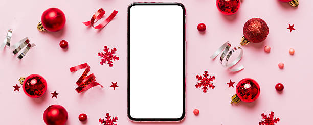 istock Christmas online shopping from home phone with blank white display top view. smart mobile with copy space on colored background with Christmas decorations balls,. Winter holidays sales background 2246021365