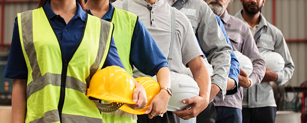 istock Engineers and factory workers standing in line with safety helmets 2246023282