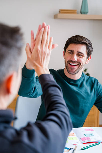 istock Happy men giving high five in office celebrating 2246027620