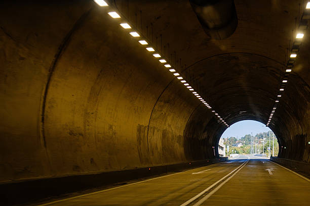 istock Road tunnel in mountain illuminated by lamps 2246028775