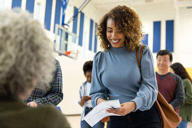 istock Diverse group of people lining up indoors, casting their votes with confidence and happiness. 2246029173