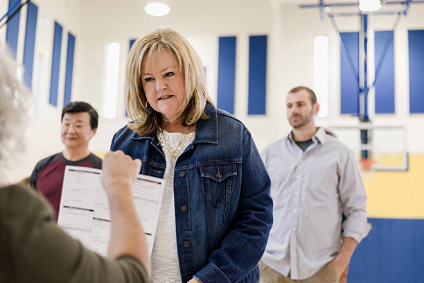 istock Diverse adults interacting in a gymnasium, possibly at a community event or voting location. 2246029195