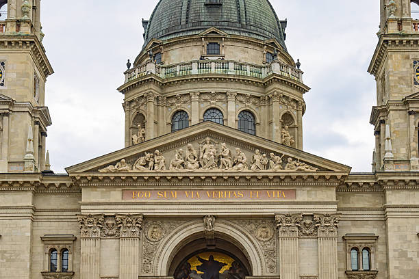 A front-facing view of the grand cathedral in Eger, showcasing its classical architecture with columns, statues, and twin towers. The surrounding greenery and distant hills enhance the elegance of this iconic landmark.
