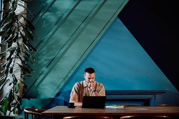 istock Young man remote working on laptop in cafe 2246033866