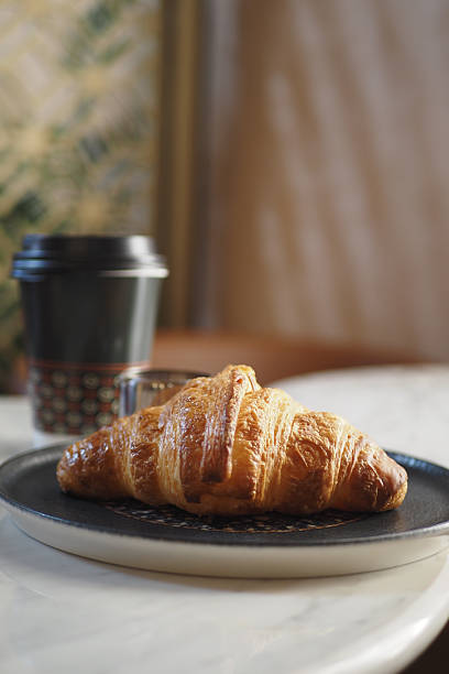 istock Freshly baked croissant paired with coffee on a table 2246035274