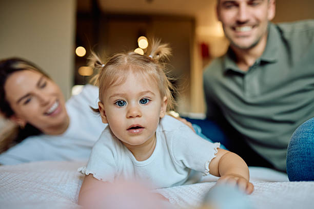 istock Happy parents playing with toddler daughter on bed 2246036740