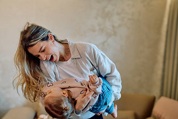 istock Happy mother playing with smiling baby at home 2246036883