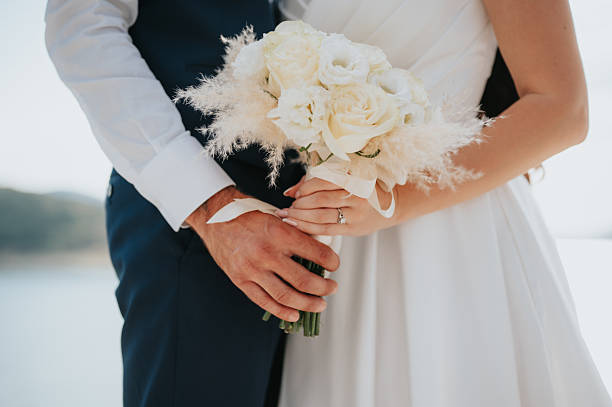 istock Bride and groom's hands and the wedding bouquet 2246038145