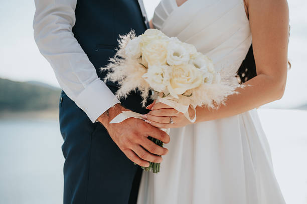 istock Bride and groom's hands and the wedding bouquet 2246038147