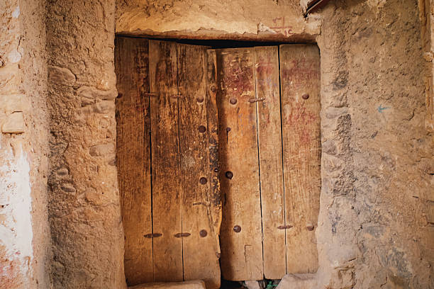 istock Rustic Ancient Wooden Door in Stone Wall 2246038387