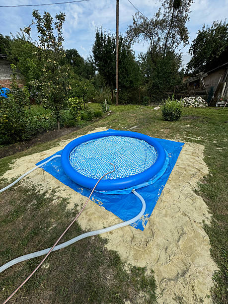 istock Inflatable blue pool being filled with water on sand base in backyard garden 2246038685