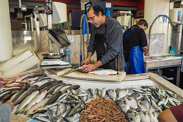 Elegant lady at market to fish counter - The seller is putting callinectes sapidus blue crabs into the bag - blue crabs are american atlantic coasts - They cause damage to fishing by preying on clams