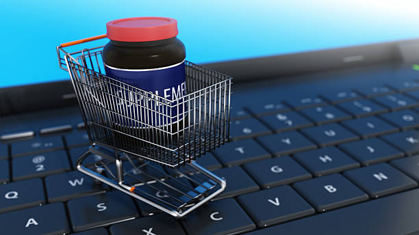 istock Online shopping cart contains a supplements bottle on a laptop keyboard representing e-commerce and convenience 2246048481