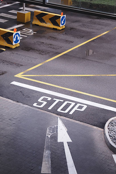 A yellow line with the word Bus Stop written in black is on the road. The line is clearly visible and the word is written in a bold, black font. This is a stop sign for buses